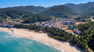 an aerial view of a beach with mountains in the background at Samcheok The Ggeullim Pension in Samcheok +2 photos