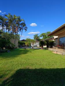 a large yard with palm trees and a building at Rancho do Mirante in Araçatuba