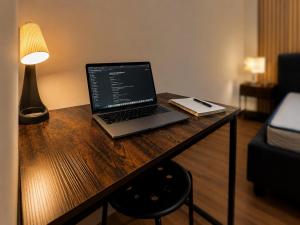 a laptop computer sitting on a wooden desk with a lamp at 77 Lisbon Design Apartment near Airport, Lisbon, Amadora, Odivelas & Sintra in Caneças +7 photos