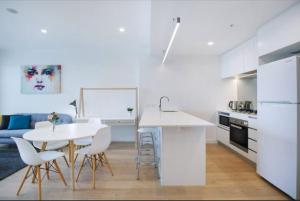 a kitchen and living room with a table and chairs at Bright CBD 2 bedroom resort-style escape in Brisbane