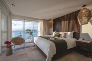 a bedroom with a large bed and a large window at Hotel Casa Bahía Cozumel - Adults Only in Cozumel +65 photos