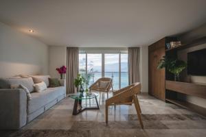 a living room with a couch and a table at Hotel Casa Bahía Cozumel - Adults Only in Cozumel