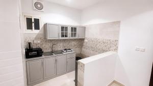a small kitchen with white cabinets and a sink at أرياف سويت in Al Baha