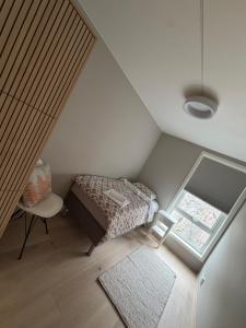 a small attic bedroom with a bed and a window at NORDIQ by the Fjord in Spro