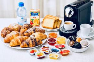 a table with plates of breakfast food and a coffee maker at Il Nido della Gioia Affittacamere in Trani