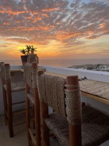 a table with chairs and a view of the ocean at Imsouane soul lodge in Imsouane