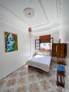 a bedroom with a bed and a painting on the wall at Imsouane soul lodge in Imsouane