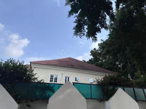 a white house with a fence in front of it at Hotel House 1 in Abuja