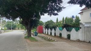 a street with a white fence and a red door at Hotel House 1 in Abuja +2 photos