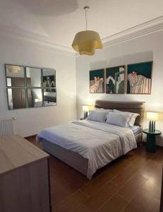 a bedroom with a bed and two lamps and pictures at Jardins de carthage in Tunis