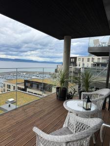 a balcony with a table and chairs and a view of the ocean at NORDIQ by the Fjord in Spro