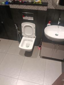 a bathroom with a white toilet and a sink at Coorg Family Villa in Gonikoppal +10 photos