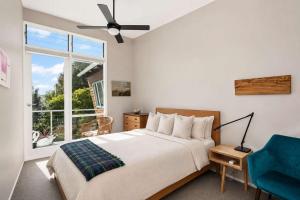 a bedroom with a bed and a window and a blue chair at Murramarang Haven in Bawley Point +32 photos