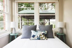 a bedroom with a bed with pillows and a window at Eurunderee House in Eurunderee