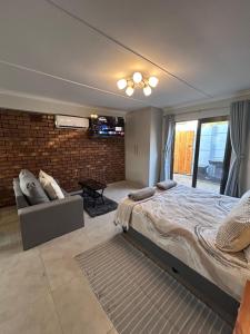 a bedroom with a large bed and a brick wall at Whale's Cove in Amanzimtoti