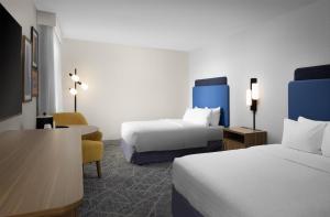 a hotel room with two beds and a chair at Hampton Inn Terre Haute in Terre Haute +23 photos