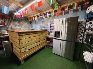 a kitchen with a counter and a refrigerator and flags at OQP Hostel Miami in Miami