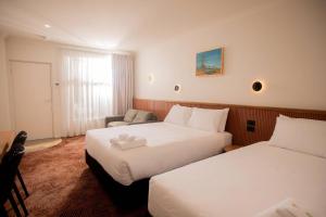a hotel room with two beds and a couch at The Alluna Motel, an Ascend Collection Hotel in Armidale +120 photos