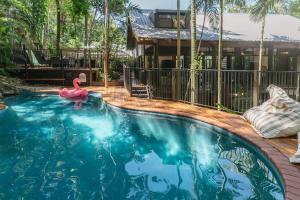 a swimming pool with a pink flamingo in front of a house at The Treehouse - Rainforest Home - Pool in Smithfield