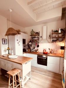 a kitchen with white appliances and a wooden counter top at A Casa das Nenas in Villanueva de Arosa