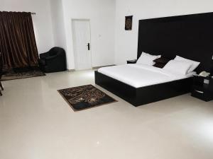 a bedroom with a bed with a black headboard at Hotel House 1 in Abuja