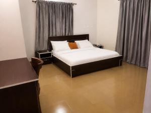 a bedroom with a bed and two night stands at Hotel House 1 in Abuja