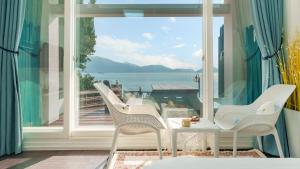 a balcony with chairs and a view of the ocean at Namhae Opera House Pension in Namhae