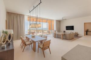a dining room and living room with a table and chairs at Park Hyatt Cabo Del Sol in Cabo San Lucas