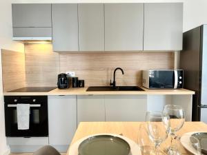 a kitchen with white cabinets and a table with wine glasses at L'AUTHENTIQUE - Moderne - Central in Mont-de-Marsan
