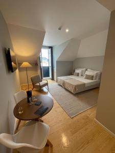 a bedroom with a bed and a table and a desk at PIER HOUSE Accommodation in Funchal