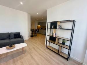a living room with a couch and a book shelf at L'AUTHENTIQUE - Moderne - Central in Mont-de-Marsan