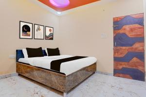 a bedroom with a bed and a door with paintings at Hotel O Smile Sweet Hotel in Pānchgaon +21 photos