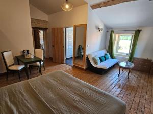 a bedroom with a bed and a couch and a table at Le Domaine de Champerou - Chambres d'hôtes in Cabariot