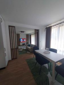 a room with a table and chairs and a living room at The Cozy Backyard Home- satu Mare in Satu Mare +1 photo