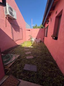 an alley between two pink buildings with a table and a air conditioner at La Rosadita in Concordia