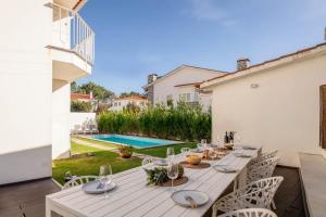 a patio with a table and chairs and a pool at Portugal Active Cabedelo Beach Lodge - Heated Pool in Viana do Castelo