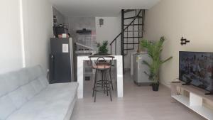 a living room with a couch and a kitchen at SandritaHouse in Tuluá