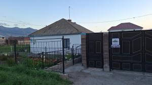 a house with a black gate and a fence at Guest House Aska Ethno in Kochkorka +2 photos