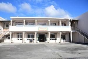 an empty parking lot in front of a white building at BnB Mahebourg apartment 2 in Mahébourg