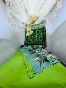 a bedroom with a green bed with a canopy at Kalpho Art Center Guesthouse- near Embassy District in Kigali