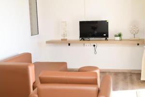a living room with a couch and a flat screen tv at BnB Mahebourg apartment 2 in Mahébourg