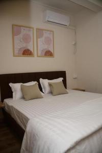 a bedroom with a large bed with white sheets and pillows at BnB Mahebourg apartment 2 in Mahébourg