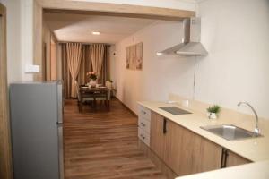 a kitchen with a refrigerator and a table in it at BnB Mahebourg apartment 2 in Mahébourg +6 photos