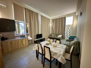 ein Wohnzimmer mit Tisch und Stühlen und eine Küche in der Unterkunft Rodia 2 in Pteleos