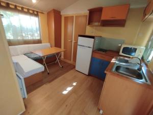a small kitchen with a refrigerator and a table at Falaguera Bungalow 5 in Bárig