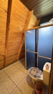 a bathroom with a toilet in a wooden room at Chácara Três Chalés in Foz do Iguaçu +14 photos