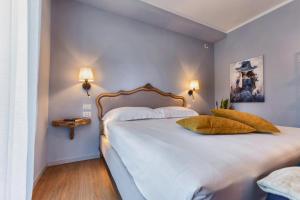 a bedroom with a large white bed with two pillows at My Tuscany Turquoise Suite in San Quirico dʼOrcia