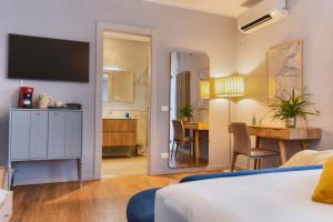 a hotel room with a bed and a dining room at My Tuscany Turquoise Suite in San Quirico dʼOrcia