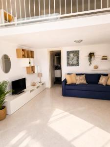 a living room with a blue couch and a tv at Maridea - Il Borgo in Ponza