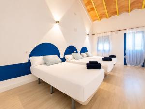 a room with three white couches and blue accents at Vientos de Tabarca 4 in Tabarca